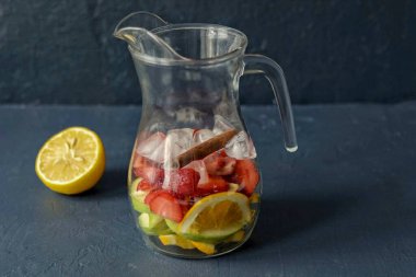 Limonun suyunu sıkıp çıkar. Sürahiye tarçın çubuğu, şurup ve buz ekle..