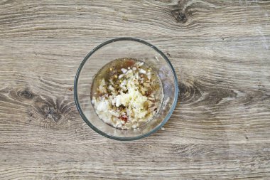 Sarımsağı soy ve doğra, sos kasesine ekle ve her şeyi karıştır..