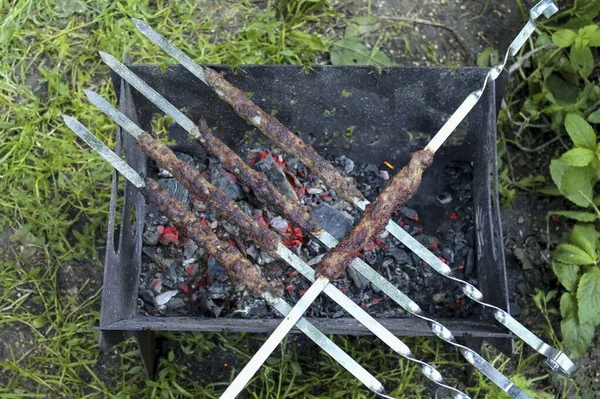 케밥을 썰어서 곳에서 익힌다 그릴에서 꺼내서 토마토 소스와 내놓는다 — 스톡 사진