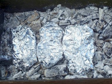 Patatesleri sıcak kömürün üzerine koyun. Aynı zamanda, bir kebap kızartılması önerilir. Patatesleri 30-40 dakika pişir..