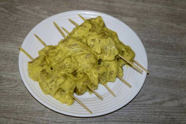 Tavuk turşusunu şişlere as. Şişleri suyla ıslattığınızdan emin olun ki pişirme sırasında yanmasınlar..