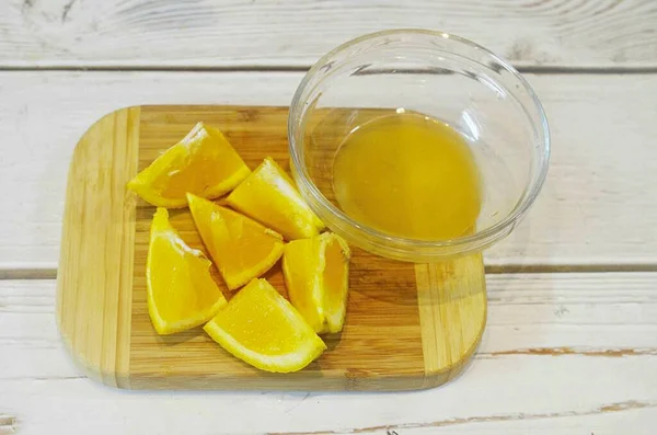 オレンジの半分からジュースを絞り 残りの半分を三角形にカットします — ストック写真
