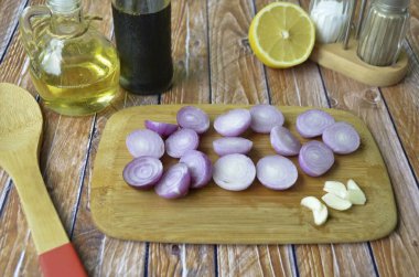 Soğan ve sarımsak soy. Her soğanı iki parçaya böl ki parçalanmasın. Sarımsağı ez ya da 3-4 parçaya böl..