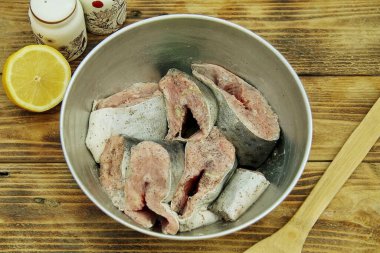 Dilimleri derin bir kaseye aktarın. Balıkların üzerine limon suyu dök, tuz ve karabiber serp. Balığı salamuraya yatırmak için 10-15 dakika bekletin..