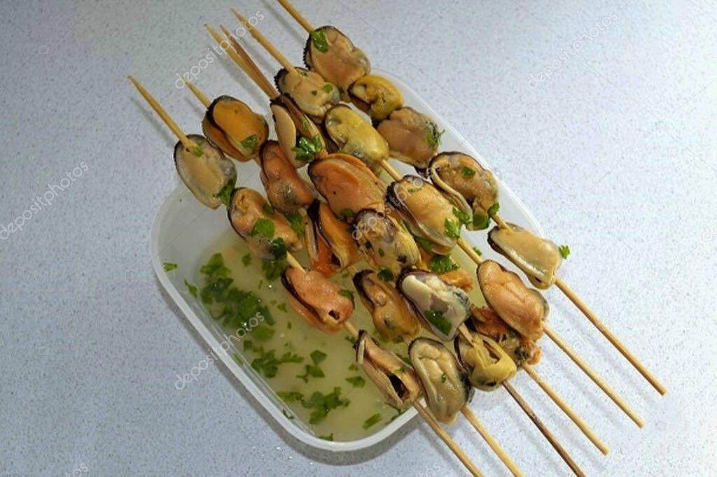 Gently string the mussels on skewers.