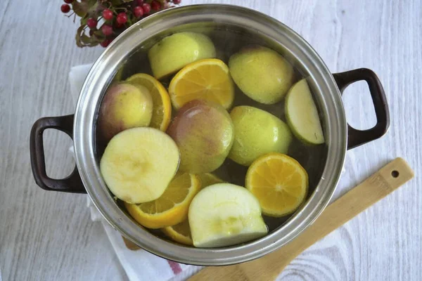 沸騰した水 鍋にリンゴとオレンジを入れて 砂糖を追加 沸騰した後 数分間コンポートを沸騰させ 熱から削除します — ストック写真