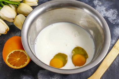 Yağlı içerikli sütü derin bir kaba dök ve tavuk yumurtalarını çırp. Tuz ve granüle şeker ekle. Tuz eklemeyi unutma! Her şeyi çırpın..