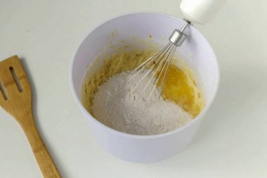 Kalan meyve suyunu ve kalan unu kaseye ekle..