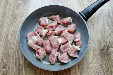 Domuzu yıka, kurula ve büyük parçalara böl. Eti tavaya koy, her zaman bir tabakta..