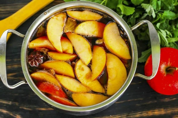 Kaynatmadan kaynayın ama ısıyı kapatın ve tavayı 10 dakika boyunca buharla kaplayın. Bu süre zarfında meyve kesimleri ve baharatlar sıvıya tat ve aroma verecek..