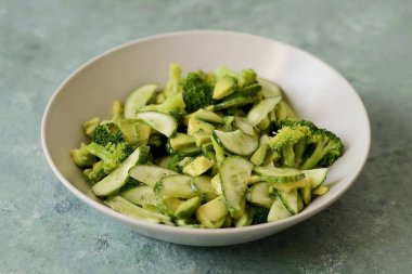 Avokado, brokoli ve salatalığı birleştirin. Limon suyu ve zeytinyağlı salata mevsimi Tuz ve biberli mevsim Kuru sarımsaklı mevsim.