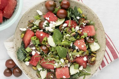 Fıstık ve feta ekle. Sos yapmak için zeytinyağı, sirke, şeker, limon suyu, tuz ve biberi birleştirin. İyice karıştır ve bir kaseye boşalt. İnanılmaz lezzetli bir salata, bitkiler, karpuz ve feta kesinlikle denemeye değer.!