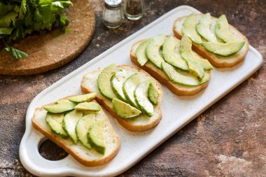 Avokadoyu ekmek dilimlerinin üstüne koy..