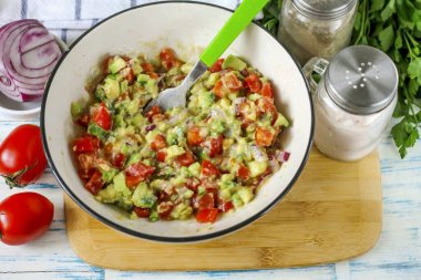 Nazikçe kabın içindekileri çatalla karıştır, nazikçe bastır, avokado dilimlerinin yarısını temizle.