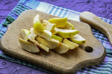 Ayvayı kesme tahtasındaki bıçakla dilimlere ayır..