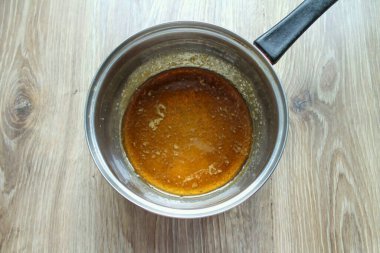 Kurutulmuş tavaya şeker koy ve az ısıt. Şeker erimeye başlayacak, tamamen eriyene kadar karıştırılacak, kehribar olana kadar..