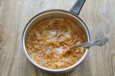 Sütü ısıt ve yavaşça şekere dök. En düşük sıcaklıkta, pürüzsüz olana kadar kaynayın. Sıcaktan uzak tut.