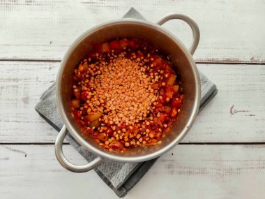 Yıkanmış mercimeği domates ezmesi için tencereye dök..