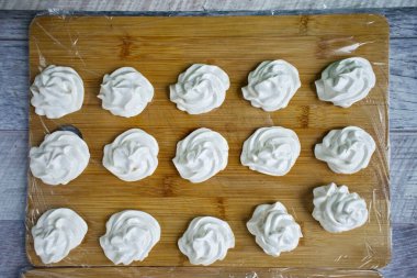 Hala sıcak olan marshmallow kütlesini derhal bir hamur torbasına naklet ve marşmelovu hazır bir çalışma yüzeyine yerleştir. Bir günlüğüne oda sıcaklığında kuru bir yerde ayrıl. Hazırlandıktan sonra, üzerine pudra şekeri serp ve bağla.