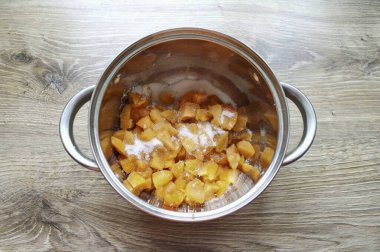 Yıka, kurula ve kayısıları kaldır. Parçalara ayrılıp ağır bir tencereye yerleştirilmiş. 100 gram şeker, kapak ve ısı ekle..