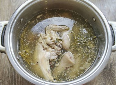 Ortalama sıcaklığın üzerine yerleştir ve kaynat. Isıyı bir saatliğine düşük seviyeye düşürün. Yeşillikleri, soğanı ve mevsimi tuzla temizleyin. Düşük ısıda 5 saat boyunca kaynayın. Sıcaktan ve soğuktan, ısınana kadar..