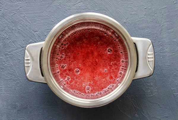 Grind the lingonberries with sugar and water with a blender until smooth. Pour into a saucepan, add vanilla syrup. Heat mashed potatoes over medium heat until almost boiling.