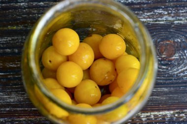 Kirazlı eriği yıka ve temiz bir 1 litre cam kavanozun altına koy..