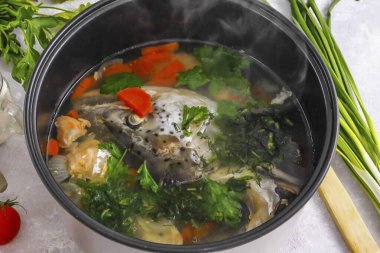 Ekran yemeğin bitmesine 10 dakika kala taze dereotu, maydanozu ya da kerevizi durula, kabaca doğra ve çoklu pişirici kaseye ekle. Sarımsak karanfilini soy ve doğra. Aynısını ekle. Teknisyen öttüğünde kulağın tadına bak. 