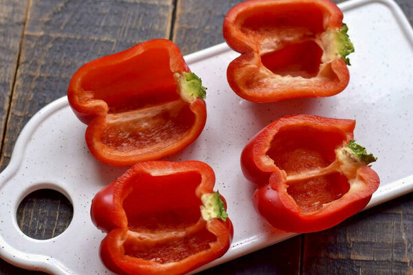 Разрежьте перец на две половинки, удалите семена, промыть, стереть влагу салфетками.