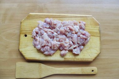 Tavuk uyluğundaki deri ve kemiği çıkarın. Ayrıca güzelce doğra..