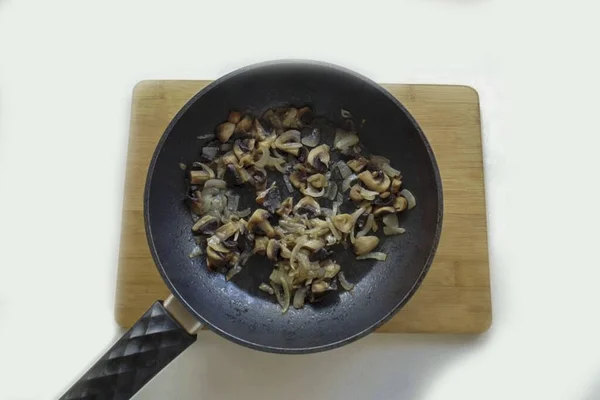 Pour vegetable oil into the pan. Fry mushrooms and onions for 7-8 minutes, stirring occasionally.