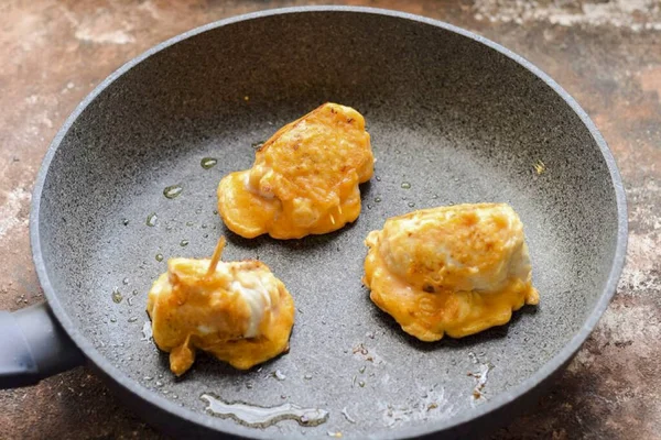 Tavuk filetosunu rulo içine sarın, kürdanla güvenle. Her parçayı hamura batır.