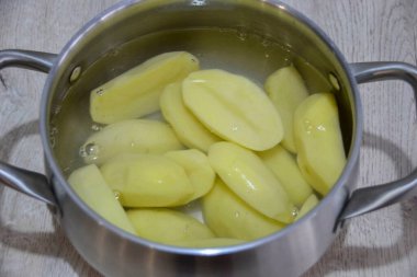 Patatesleri soy, düşük ısıda kaynatın. Patatesler sarımsak sosu hazır olduktan sonra hazır olur. Pişirmesi yarım saat sürer..