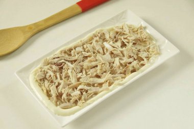 Şimdi tüm malzemeleri görsel olarak ikiye böl ve salatayı ananas şeklinde büyük bir tabağa koy: tavuk - mayonez..
