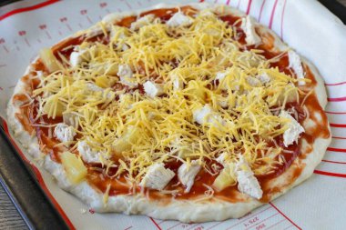 Pizzanın üstüne rendelenmiş peynir serpin..