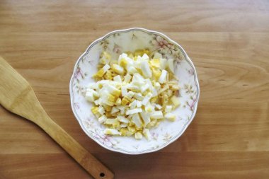 Haşlanmış yumurta, soğuk, kabuk soyup ince ince doğra. Salatada yer.