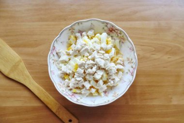 Tavuk filetosunu kaynatın, soğutun ve küçük küplere ayırın. Kesilmiş sarımsaklı karanfil ekle..