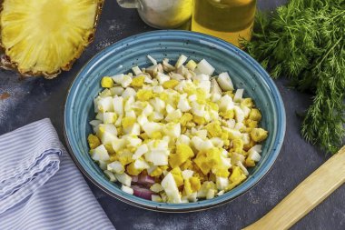 Tavuk yumurtalarını suda soyup durula, küp küp doğra ve bir kabın içine ekle..