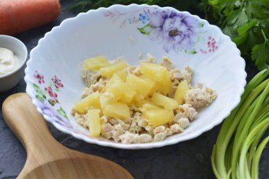 Tavuk filetosunu bir kaseye koy ve dilimlenmiş ananasları ekle.