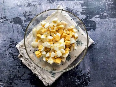 Yumurtaları soy, güzelce doğra ve mürekkep balığına ekle..