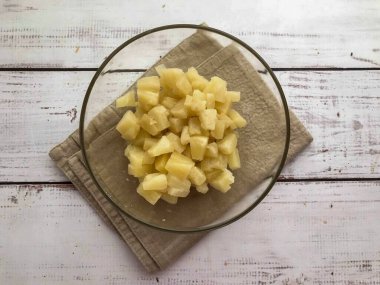 İnce doğranmış ananası derin bir tabağa koy..