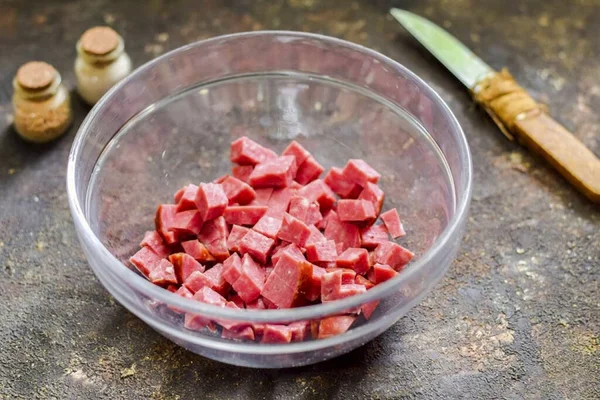 Cut the smoked sausage into small cubes and transfer to a salad bowl.