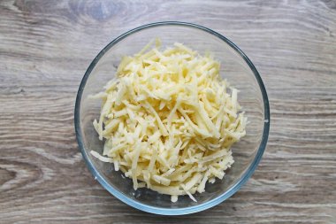 Kaba rendeleyici üzerindeki sert peyniri rendele ve salata kasesine ekle..