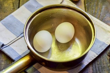 Tavuk yumurtalarını 10 dakika kaynatın. Yumurtalardan sonra, soğuk suda soğur ve soyulurlar..