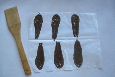 Geriye ananas yaprağı yapmak kalıyor. Çikolatayı herhangi bir şekilde erit. Parşömene çikolata yaprakları sür, tamamen sertleşene kadar soğuğu içeri gönder..