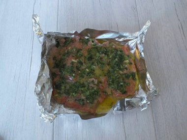 Folyonun kenarlarını yukarı katla. Salamurayı pembe somon filetosunun üzerine dök..