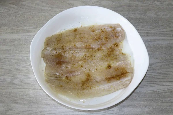 把鱼加盐 洒上香料 放入抹了油的烤盘中 — 图库照片