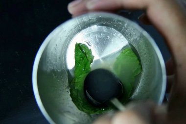 Mango ve ananas karışımı yapmak için gerekli tüm malzemeleri hazırlayın. Naneyi limon suyu ve tatlı şurupla ezin..