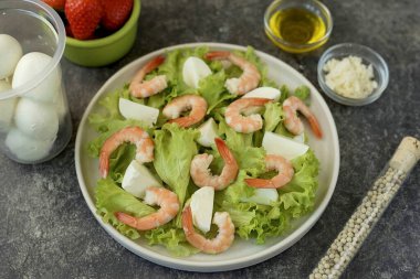 Marulu ellerinle parçala, düz bir tabağa koy, üstü karidesli olsun ve çeyrekliklere böl veya mozzarella dilimlerine böl..