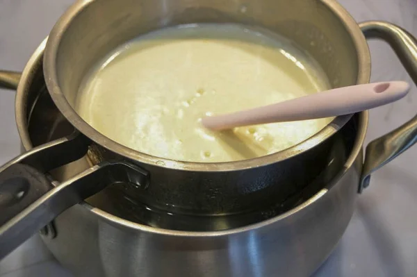 鍋が底に触れないように 水風呂 に牛乳黄身砂糖の混合物を配置し 約10分間攪拌して熱 厚くなるまで それをオーバークックしないようにしてください またはオムレツになります クールダウン — ストック写真